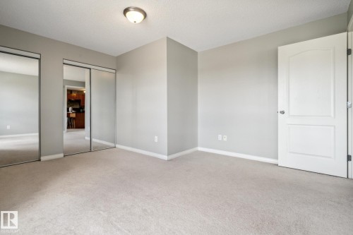 Neutral-toned room featuring light gray walls, plush carpeting, and white baseboards - 1306 330 Clareview Station Drive, Edmonton, AB - Indoor Photo Showing Other Room