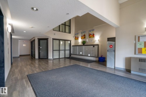 Spacious communal entryway featuring wood-finish flooring, a mailroom with individual mailboxes, and an overhead lighting scheme - 1306 330 Clareview Station Drive, Edmonton, AB - Indoor Photo Showing Other Room