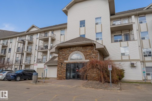 Multi-story building featuring stacked balconies with metal railings, a stone facade entryway, multiple windows, and exterior siding - 1306 330 Clareview Station Drive, Edmonton, AB - Outdoor