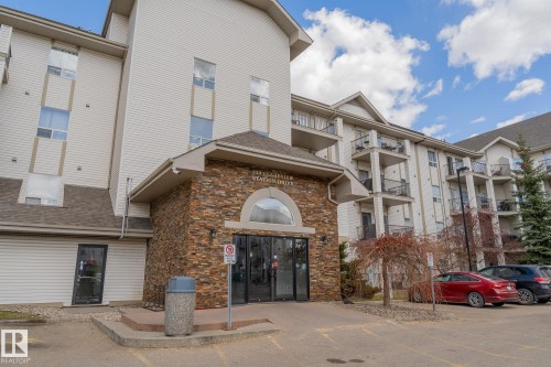 Multi-story residential building featuring a stone-clad entrance with an arched transom - 1306 330 Clareview Station Drive, Edmonton, AB - Outdoor