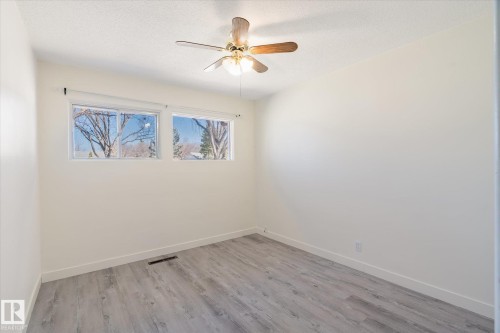 Bright interior space featuring light wood-finish flooring, white baseboards, and clean white walls - 10531 128 Avenue, Edmonton, AB - Indoor Photo Showing Other Room