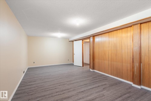 Spacious room featuring wood-finish flooring, light-toned painted walls, and a recessed ceiling light - 10531 128 Avenue, Edmonton, AB - Indoor Photo Showing Other Room