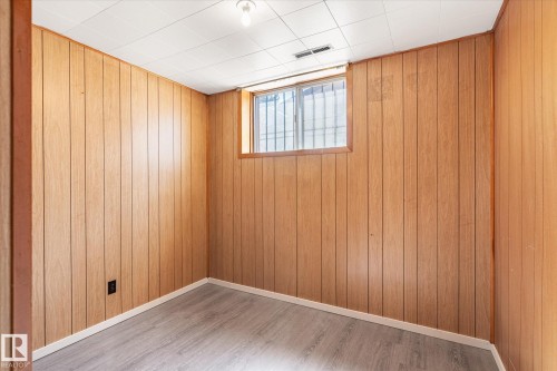 Room featuring paneling walls, wood-finish flooring, and a drop ceiling - 10531 128 Avenue, Edmonton, AB - Indoor Photo Showing Other Room