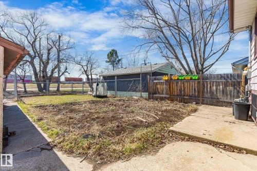 Expansive backyard space featuring a chain-link fence, a wood privacy fence, and mature trees - 10531 128 Avenue, Edmonton, AB - Outdoor