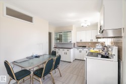 Kitchen featuring white cabinetry, tile backsplash, stainless steel range hood, and tile flooring - 