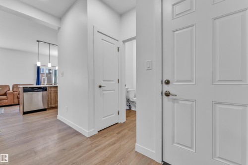 Entryway featuring wood-finish flooring, white paneled doors, and contemporary white walls - 41 603 Orchards Boulevard, Edmonton, AB - Indoor Photo Showing Other Room