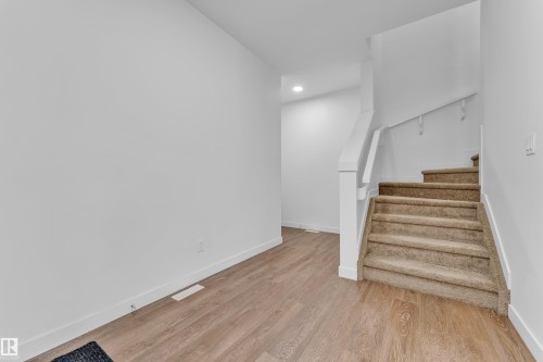 Carpeted staircase featuring white railings and risers - 41 603 Orchards Boulevard, Edmonton, AB - Indoor Photo Showing Other Room