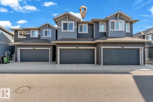 Contemporary townhome exterior featuring multi-toned siding, gabled rooflines, and a dark asphalt shingle roof - 41 603 Orchards Boulevard, Edmonton, AB - Outdoor With Facade