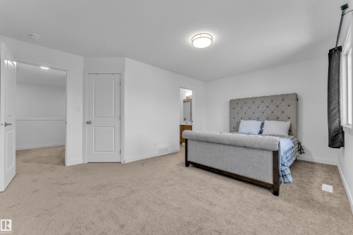 Carpeted room with white walls, two white two-panel doors, and a window - 41 603 Orchards Boulevard, Edmonton, AB - Indoor Photo Showing Bedroom