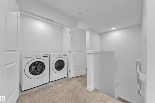 Dedicated laundry area featuring front-loading appliances, neutral wall colors, and recessed lighting - 41 603 Orchards Boulevard, Edmonton, AB - Indoor Photo Showing Laundry Room
