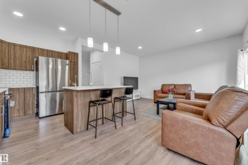 Open-concept living area with wood-finish flooring throughout - 41 603 Orchards Boulevard, Edmonton, AB - Indoor Photo Showing Kitchen
