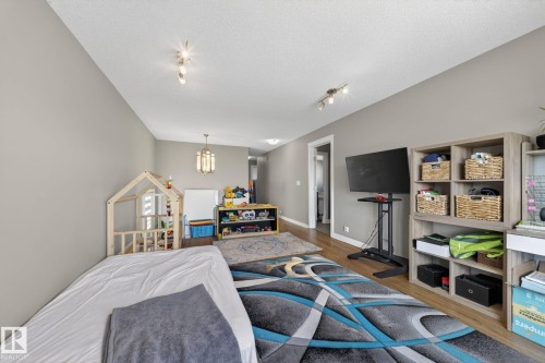 Spacious room featuring wood-finish flooring, light grey walls, and a recessed ceiling with track lighting - 3639 15A Street, Edmonton, AB - Indoor Photo Showing Bedroom