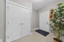 Entryway featuring light-toned tile flooring, a white paneled entry door, and a white bi-fold closet door with satin nickel hardware - 3639 15A Street, Edmonton, AB  - Indoor Photo Showing Other Room 
