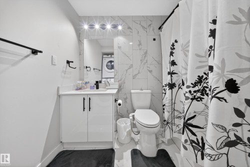 Modern bathroom featuring a white vanity with black hardware, a rectangular sink, and a mirrored medicine cabinet - 3639 15A Street, Edmonton, AB - Indoor Photo Showing Bathroom
