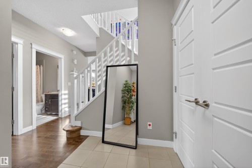 Entryway featuring a tiled floor and an open staircase with white balusters - 3639 15A Street, Edmonton, AB - Indoor Photo Showing Other Room