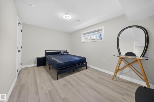 Spacious room featuring light wood-finish flooring, neutral wall paint, and a white ceiling with recessed lighting - 3639 15A Street, Edmonton, AB - Indoor Photo Showing Bedroom
