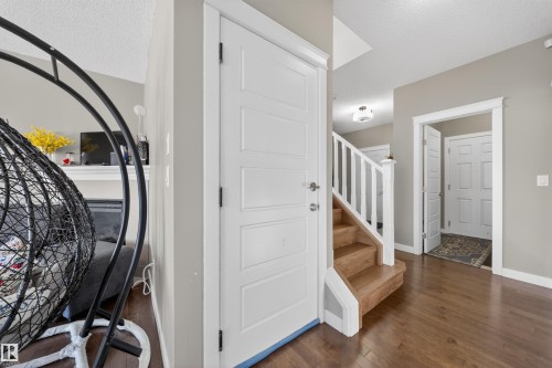 Entryway featuring wood-finish flooring, white paneled doors, and a staircase with white risers and wood treads - 3639 15A Street, Edmonton, AB - Indoor Photo Showing Other Room