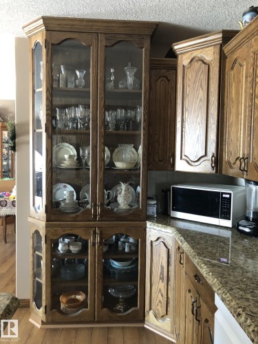 Custom built-in display cabinetry featuring glass-front doors and wood-finish construction - 123064 Hwy 45, Rural Two Hills County, AB 