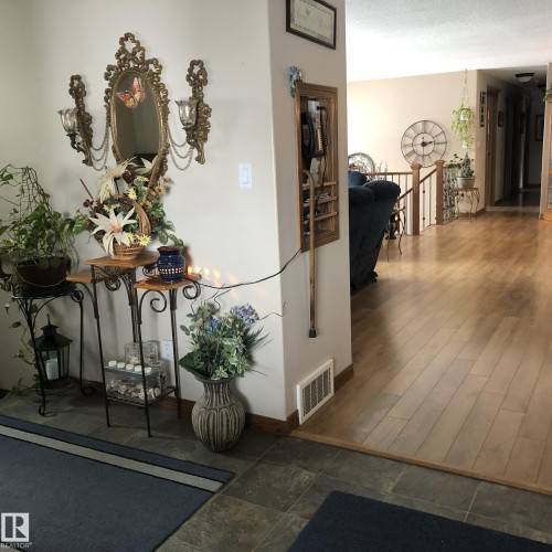 Entryway featuring large format tile flooring transitioning to wood-finish flooring - 123064 Hwy 45, Rural Two Hills County, AB 