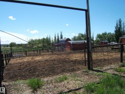 Fenced outdoor enclosure featuring multiple red outbuildings - 