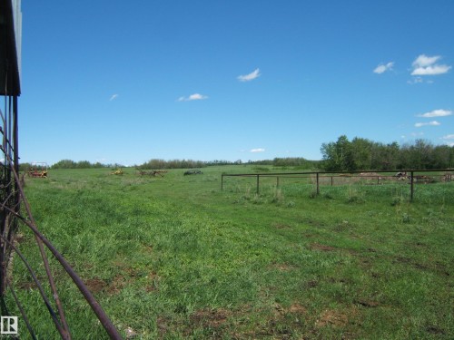 Expansive green pastureland with perimeter fencing and a distant tree line - 123064 Hwy 45, Rural Two Hills County, AB 