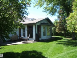Spacious green lawn with mature trees and a concrete patio - 