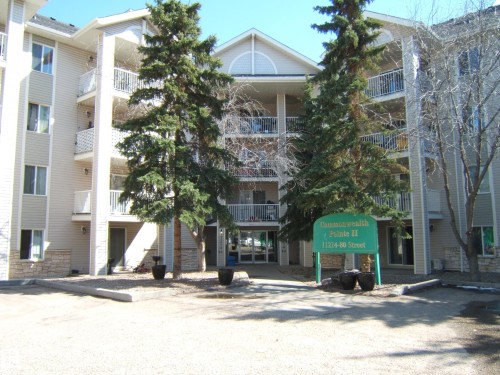 Multi-story residential building featuring light-toned siding and multiple balconies - 105 11214 80 Street, Edmonton, AB - Outdoor With Facade