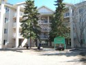 Multi-story residential building featuring light-toned siding and multiple balconies - 105 11214 80 Street, Edmonton, AB  - Outdoor With Facade 