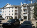 Multi-story residential building featuring light-colored siding and stone accents - 105 11214 80 Street, Edmonton, AB  - Outdoor 