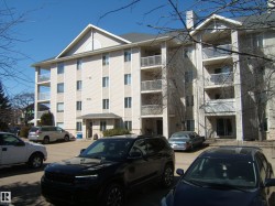 Multi-story building featuring light-colored siding and multiple private balconies with white railings - 