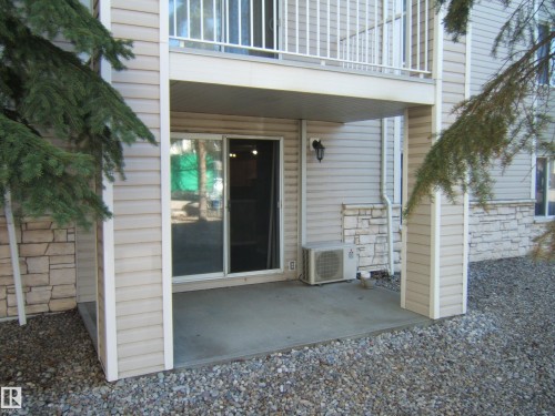 Covered concrete patio with sliding glass door access - 105 11214 80 Street, Edmonton, AB - Outdoor With Exterior