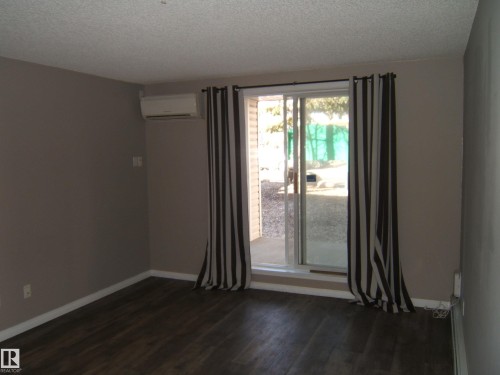 Interior space featuring wood-finish flooring and neutral wall tones - 105 11214 80 Street, Edmonton, AB - Indoor Photo Showing Other Room