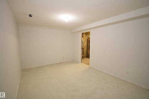 Carpeted room with white painted walls and ceiling, featuring an exposed beam - 11 230 Edwards Drive, Edmonton, AB - Indoor Photo Showing Other Room