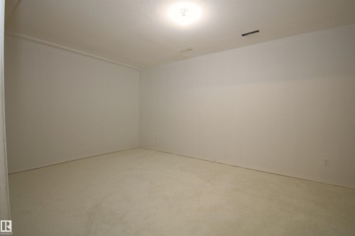 Spacious room featuring neutral carpeting and light-toned walls - 11 230 Edwards Drive, Edmonton, AB - Indoor Photo Showing Other Room