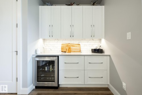 Built-in beverage refrigerator with white shaker-style cabinetry - 108 7463 May Common, Edmonton, AB - Indoor