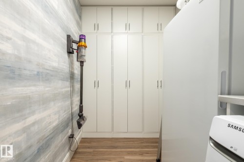 Integrated storage cabinetry with multiple upper and lower doors, wood-finish flooring, and a contemporary wall treatment - 108 7463 May Common, Edmonton, AB - Indoor