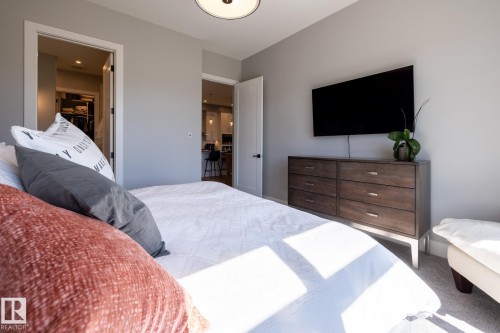 Spacious room with light gray walls, plush carpet, and a modern ceiling light fixture - 108 7463 May Common, Edmonton, AB - Indoor Photo Showing Bedroom