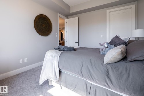 Carpeted room with light gray walls, white baseboards, and white ceiling trim - 108 7463 May Common, Edmonton, AB - Indoor Photo Showing Bedroom