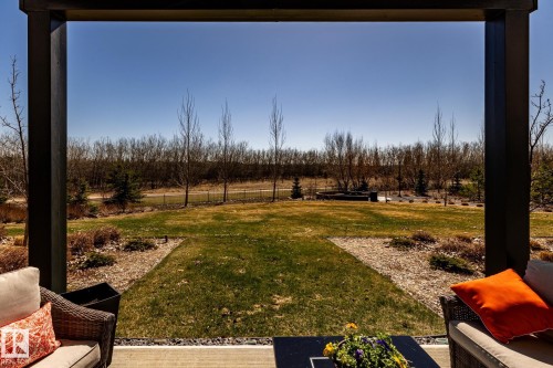 Covered patio with a concrete slab, overlooking a spacious lawn and landscaped gardens - 108 7463 May Common, Edmonton, AB - Outdoor