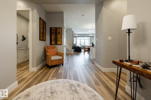 Hallway featuring wood-finish flooring, light grey wall paint, and white baseboards - 108 7463 May Common, Edmonton, AB - Indoor Photo Showing Other Room
