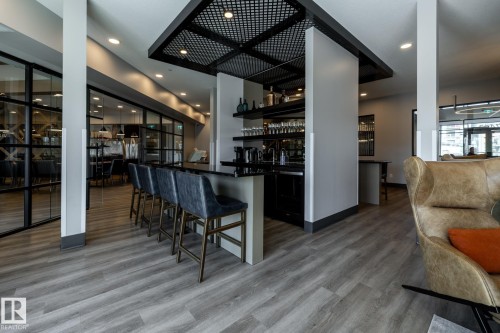 Contemporary bar area featuring black cabinetry, dark countertops, and open shelving - 108 7463 May Common, Edmonton, AB - Indoor