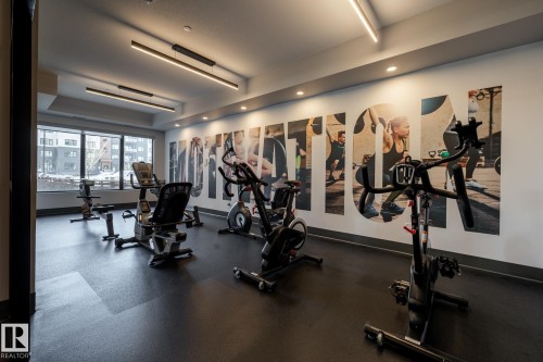Fitness area featuring large window panels, recessed lighting, and a durable rubberized floor - 108 7463 May Common, Edmonton, AB - Indoor Photo Showing Gym Room