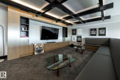 Integrated media wall with built-in cabinetry and shelving - 108 7463 May Common, Edmonton, AB - Indoor Photo Showing Other Room