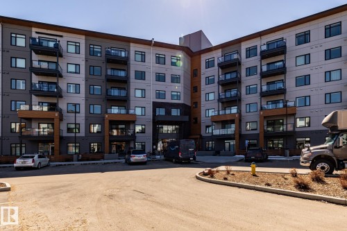 Modern multi-story building featuring a contemporary facade with grey and wood-toned paneling - 108 7463 May Common, Edmonton, AB - Outdoor With Facade