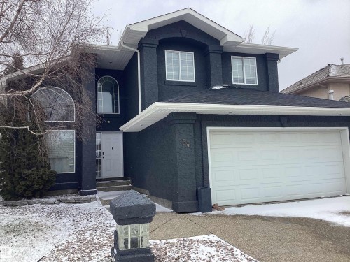 Contemporary two-story residence featuring a dark stucco exterior, prominent white trim, and a shingled roof - 54 Leonard Drive, St. Albert, AB - Outdoor