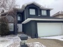 Contemporary two-story residence featuring a dark stucco exterior, prominent white trim, and a shingled roof - 54 Leonard Drive, St. Albert, AB  - Outdoor 