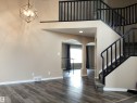 Foyer featuring wood-finish flooring, a modern geometric chandelier, and a curved staircase with black railings - 54 Leonard Drive, St. Albert, AB  - Indoor Photo Showing Other Room 