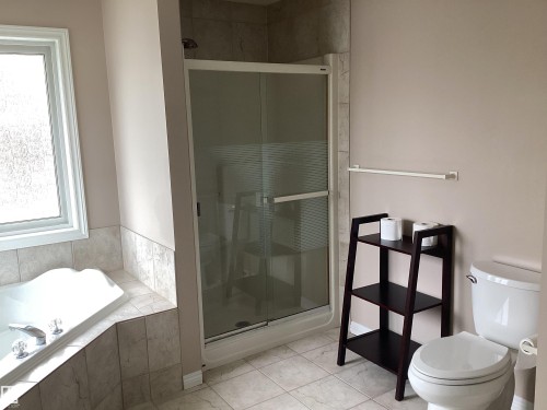 Corner soaking tub with tiled surround, adjacent to a glass-enclosed shower - 54 Leonard Drive, St. Albert, AB - Indoor Photo Showing Bathroom