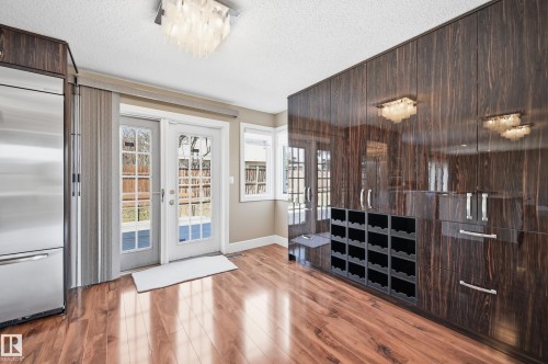 Hardwood-finish flooring complementing high-gloss cabinetry featuring an integrated wine rack - 394 Walker Road, Edmonton, AB - Indoor Photo Showing Other Room