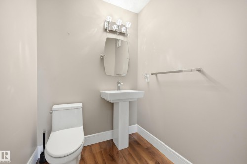 Pedestal sink with chrome faucet, complemented by a contemporary mirror and vanity light - 394 Walker Road, Edmonton, AB - Indoor Photo Showing Bathroom